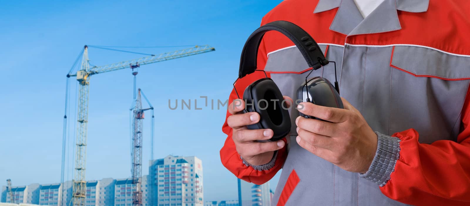 protective headphone at man hands on building background