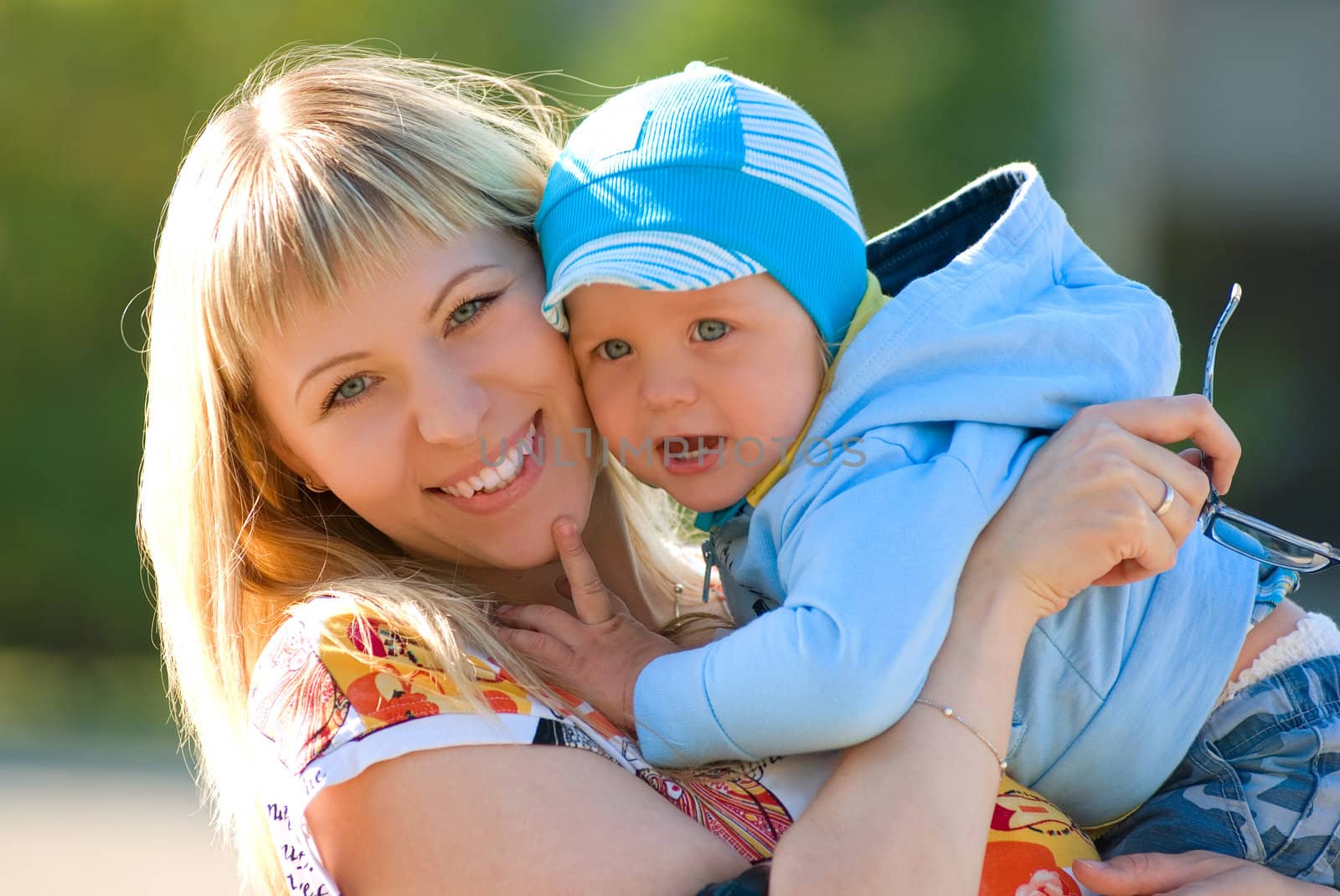 Mother cuddling young son, outdoor portraits