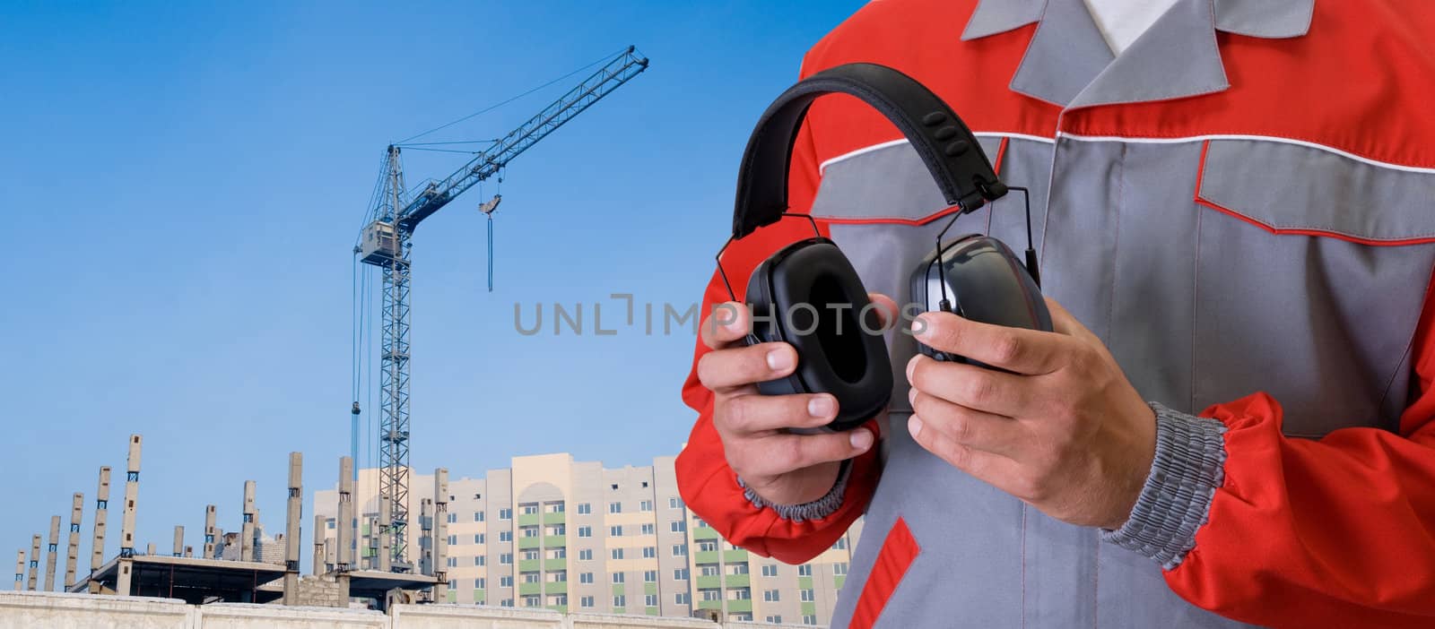 protective headphone at man hands on building background