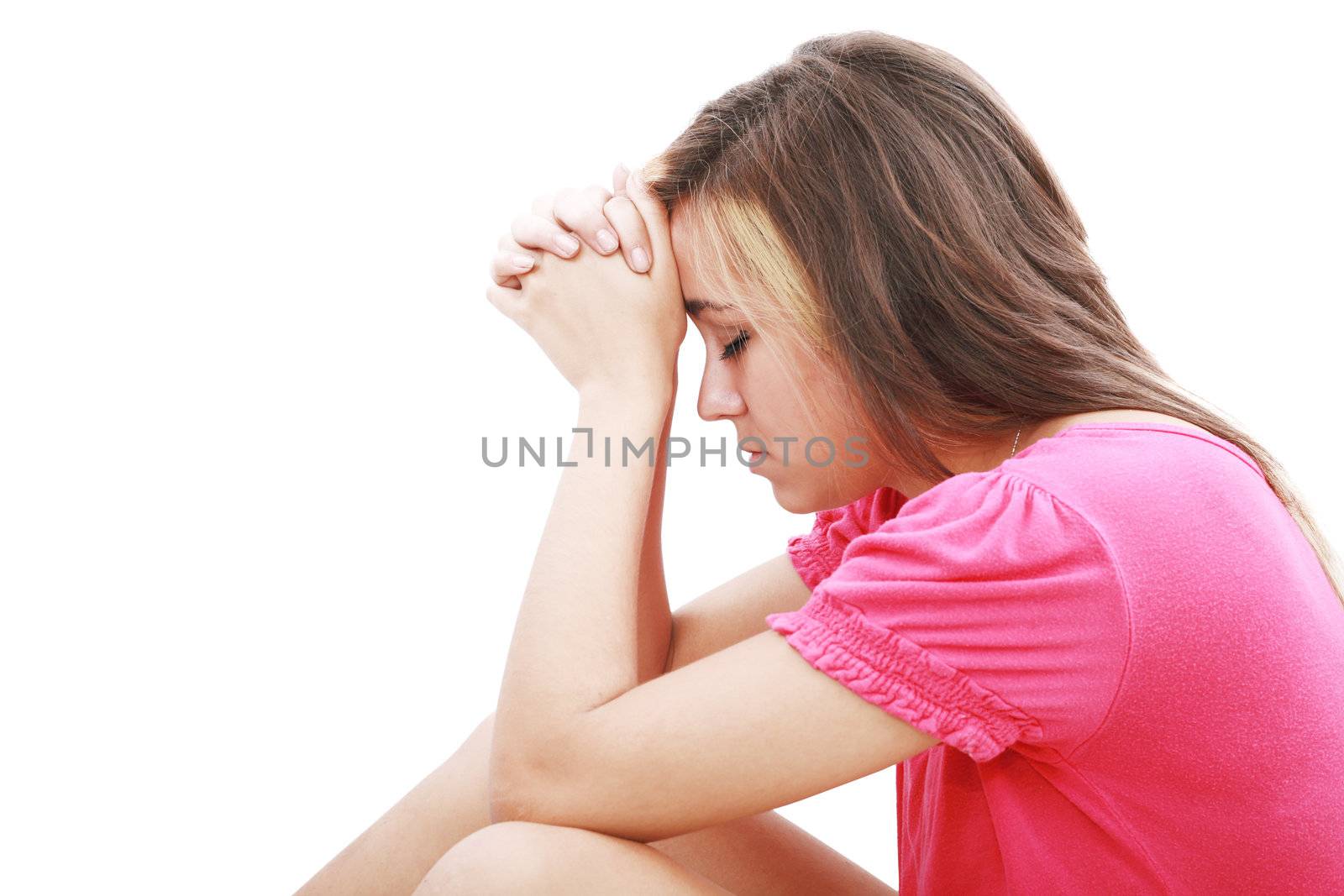 Young woman praying sincerely with her hands folded and eyes closed