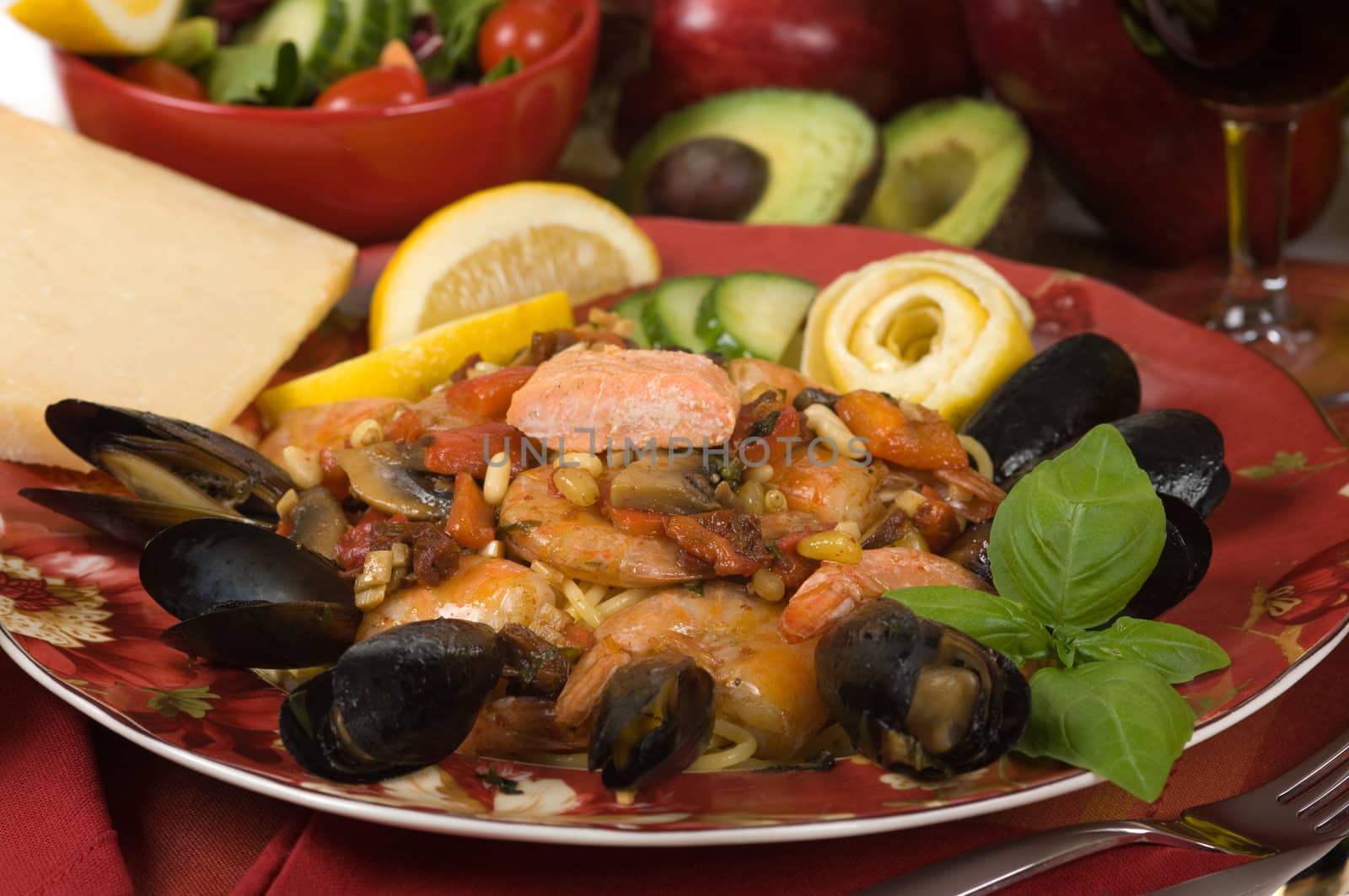 Seafood dinner made with shrimp, mussel, salmon, sun dried tomato, roasted red pepper, pine nuts, mushroom, garlic, basil  and noodles 