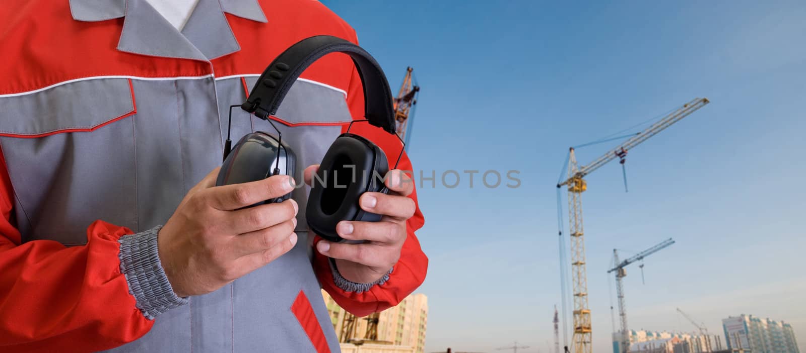 protective headphone at man hands on building background