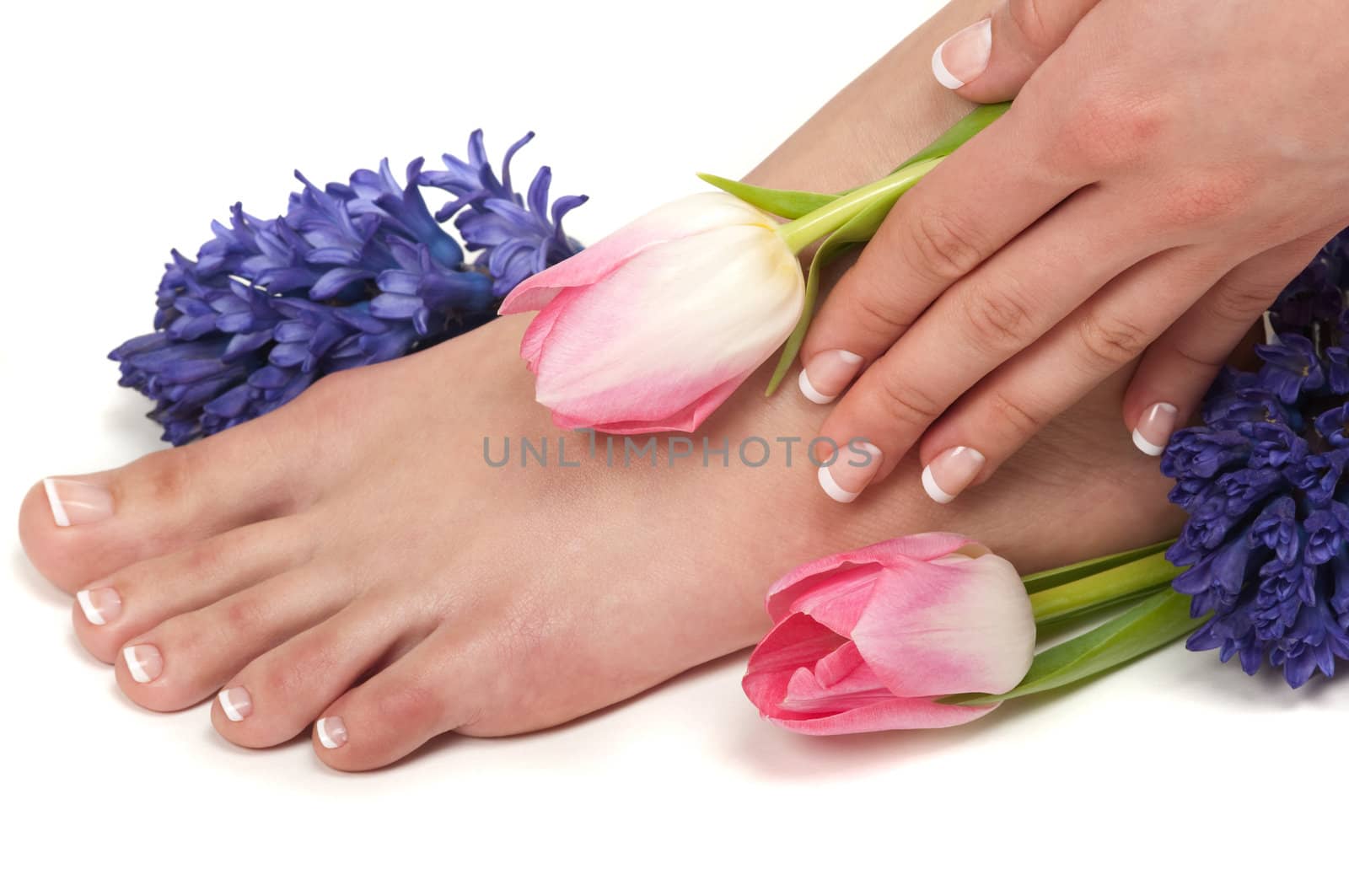 Pedicured feet, manicured hands and aromatic flowers in a spa