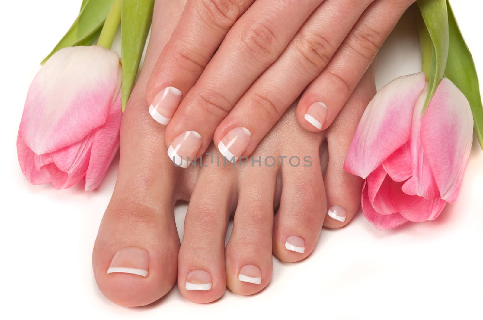 Pedicured feet and manicured hands with Easter tulips