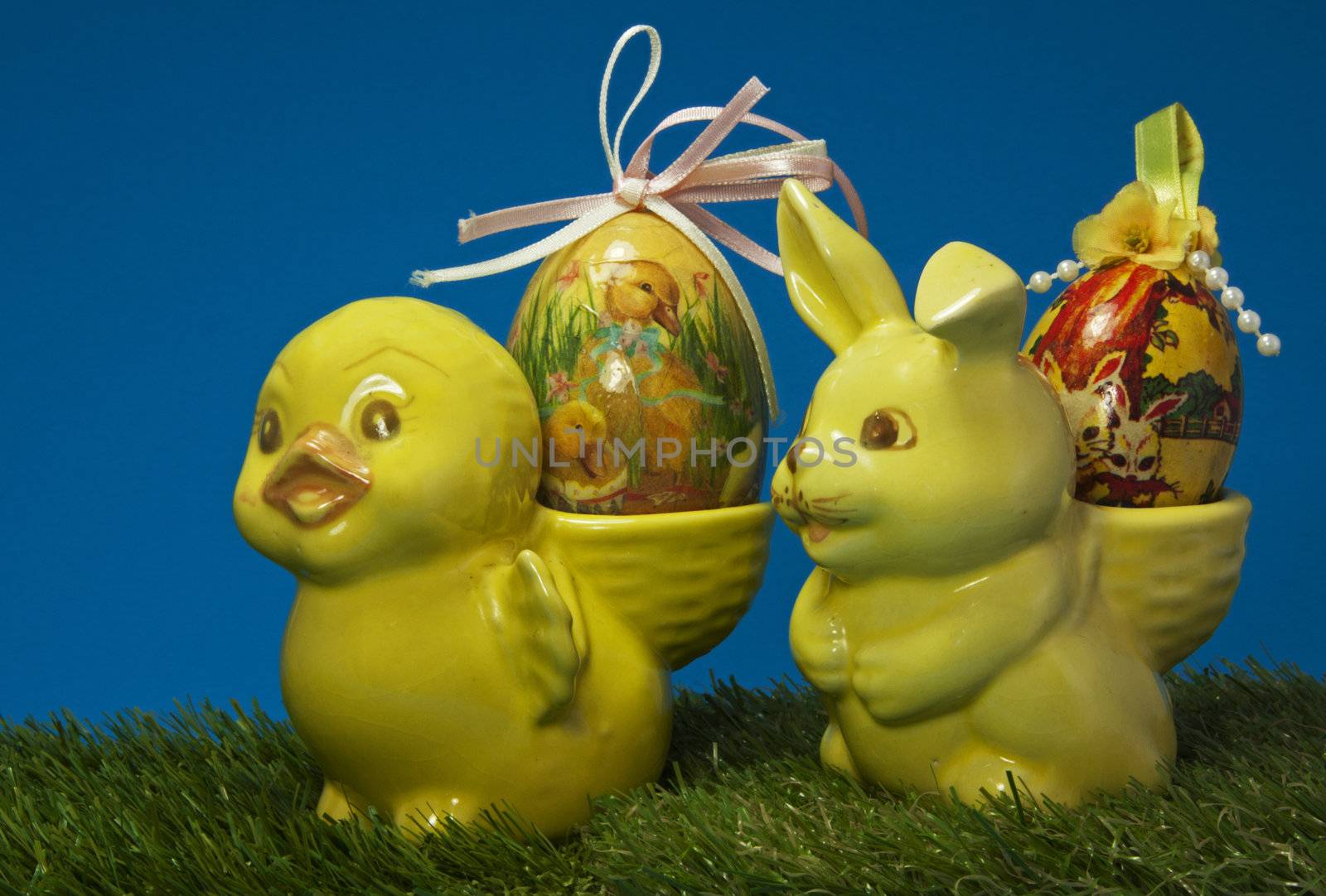 yellow easter duck and bunne in green grass with blue background