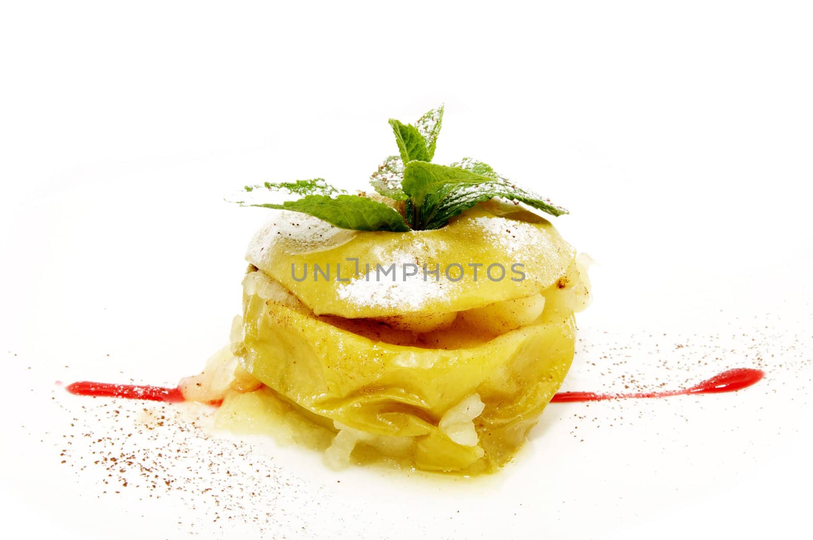 Baked apple decorated with mint on a white plate