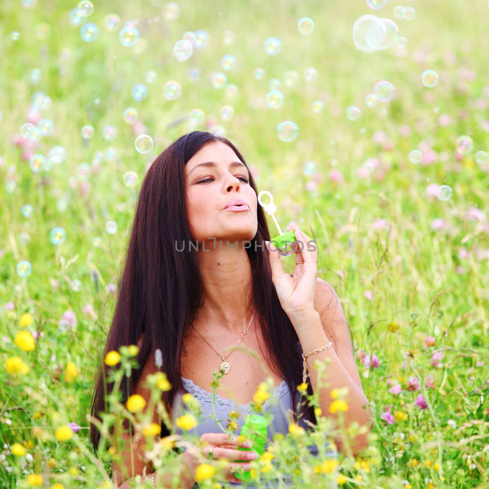  happy woman smile in green grass soap bubbles around