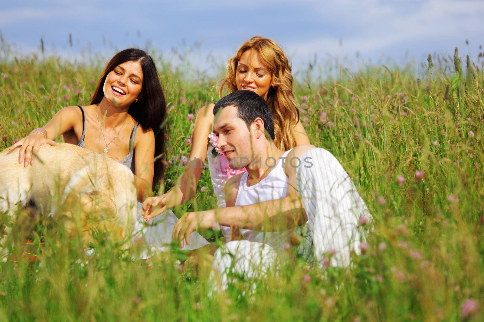 friends and dog in green grass field