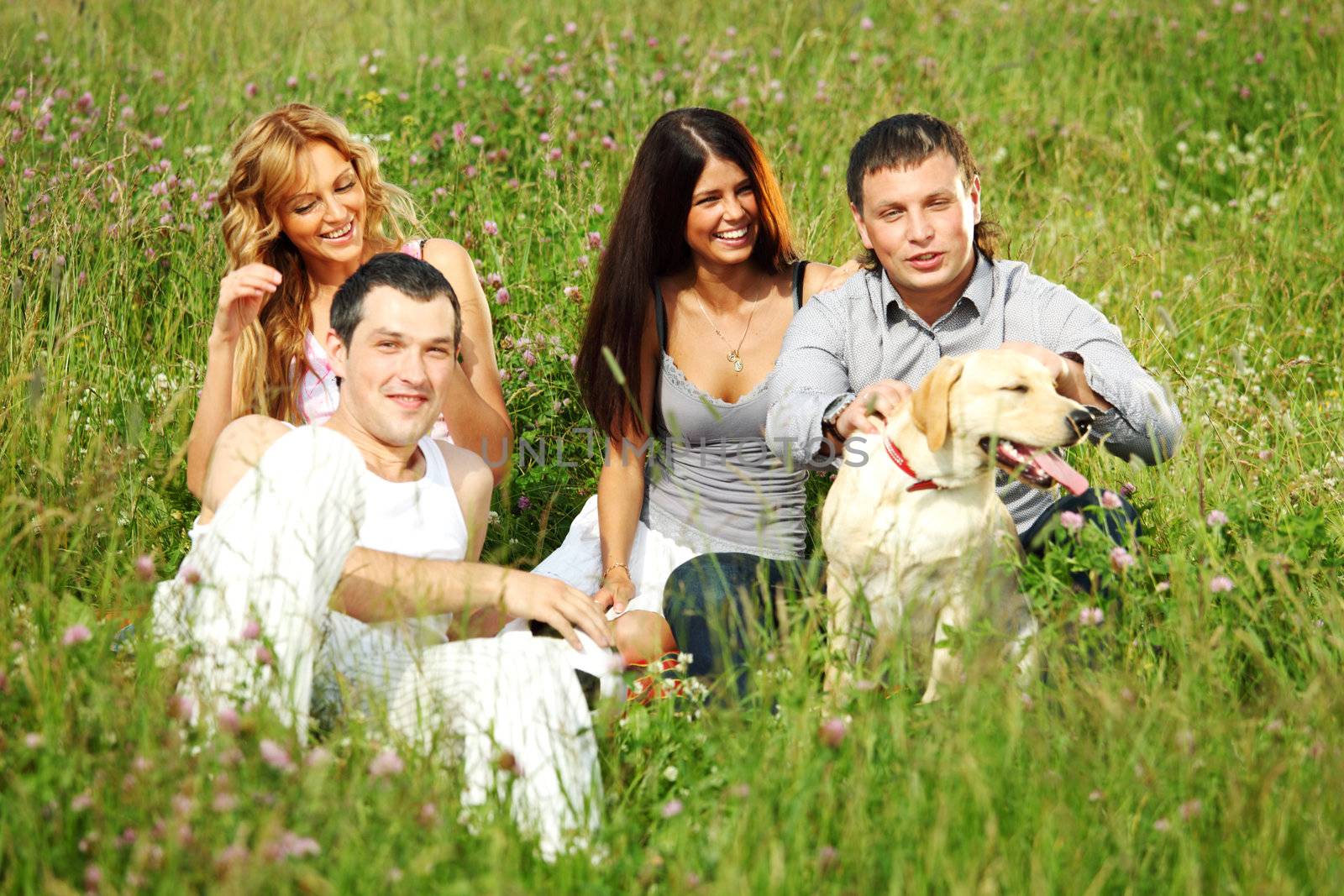 friends and dog in green grass field