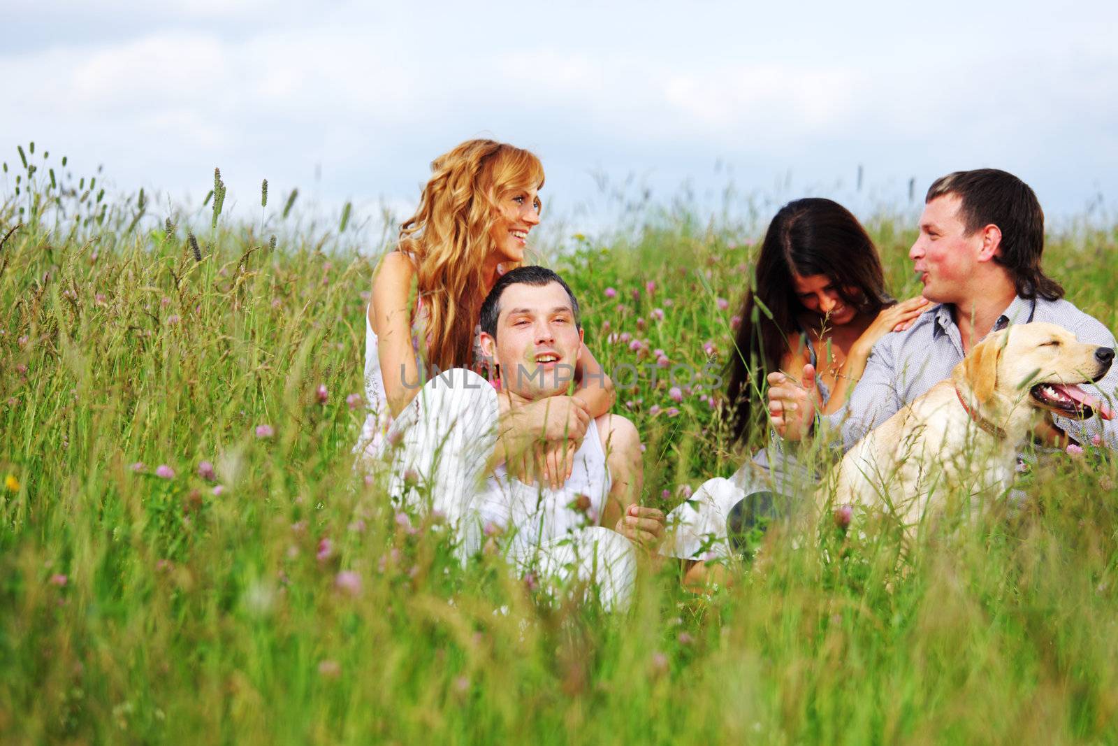 friends and dog in green grass field