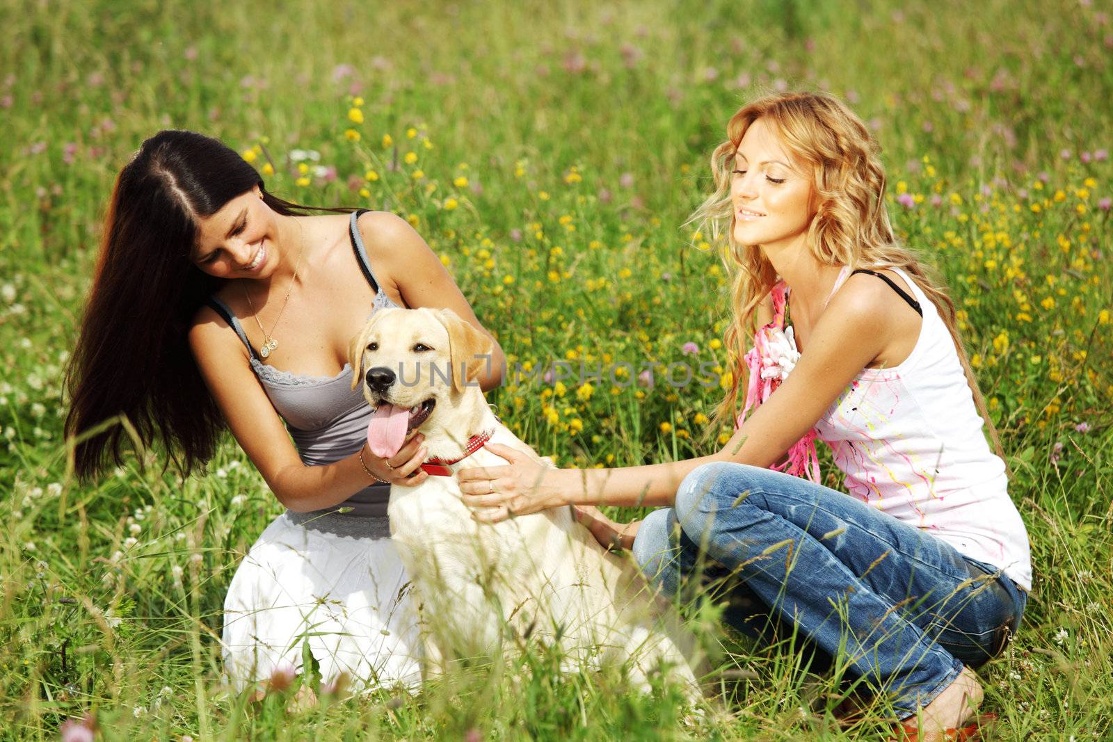 girlfriends and dog in green grass field