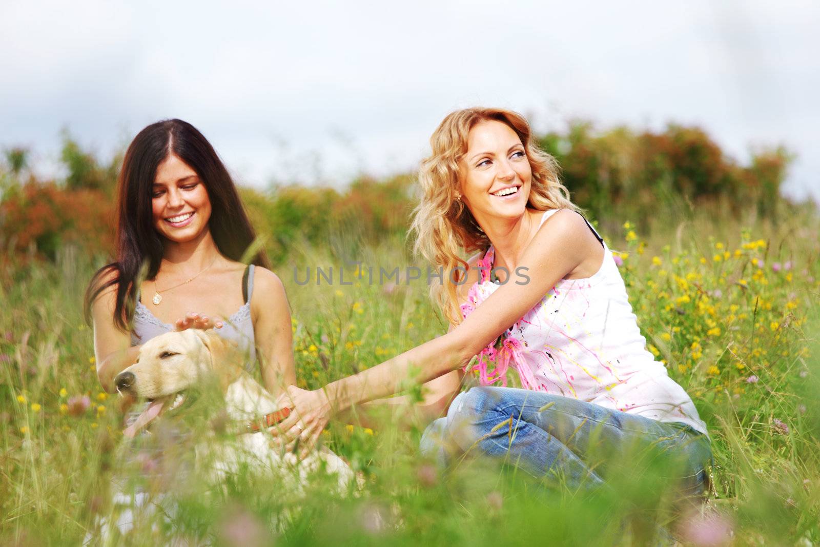 girlfriends and dog in green grass field