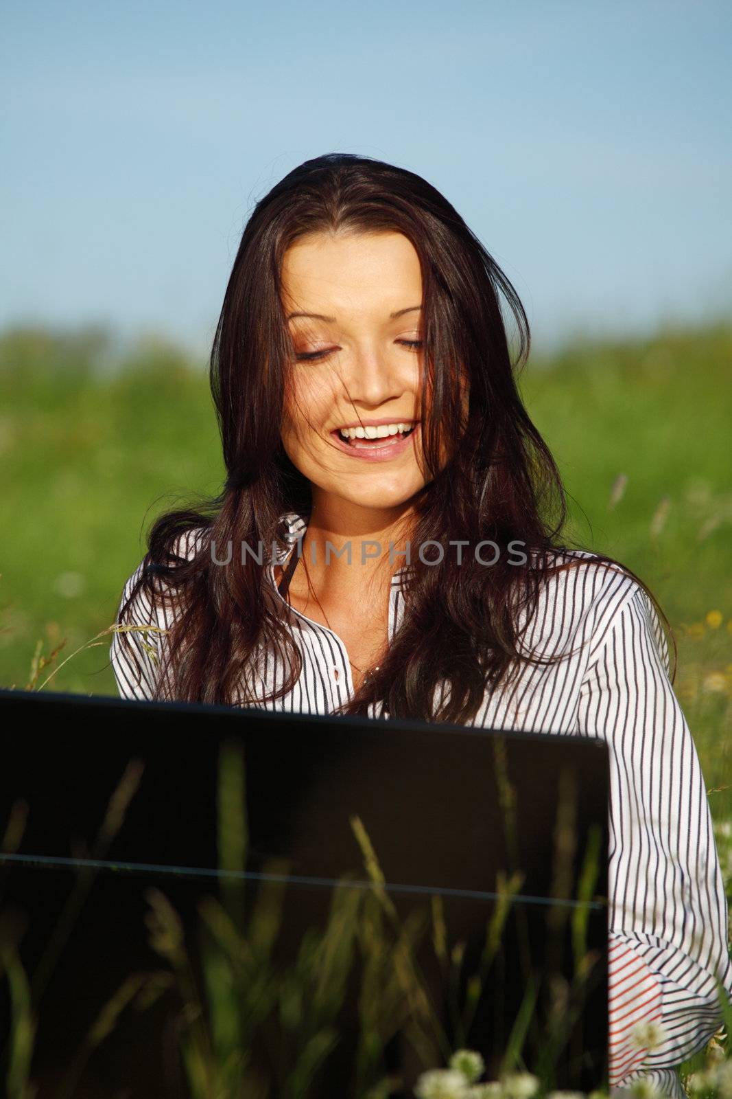 girl with laptop on green grass