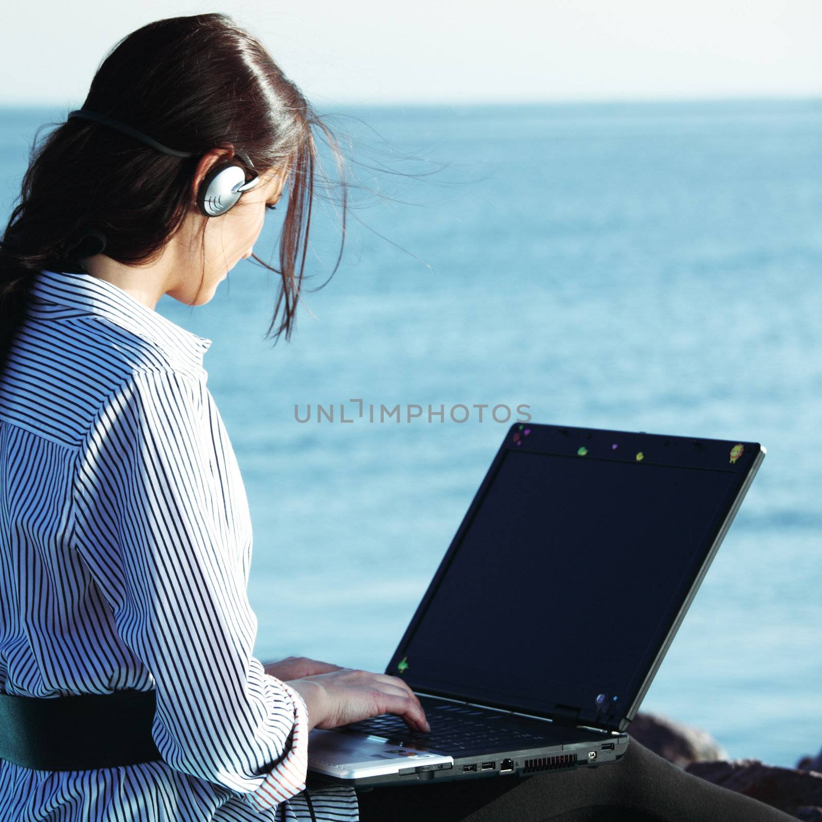 woman with laptop sea background