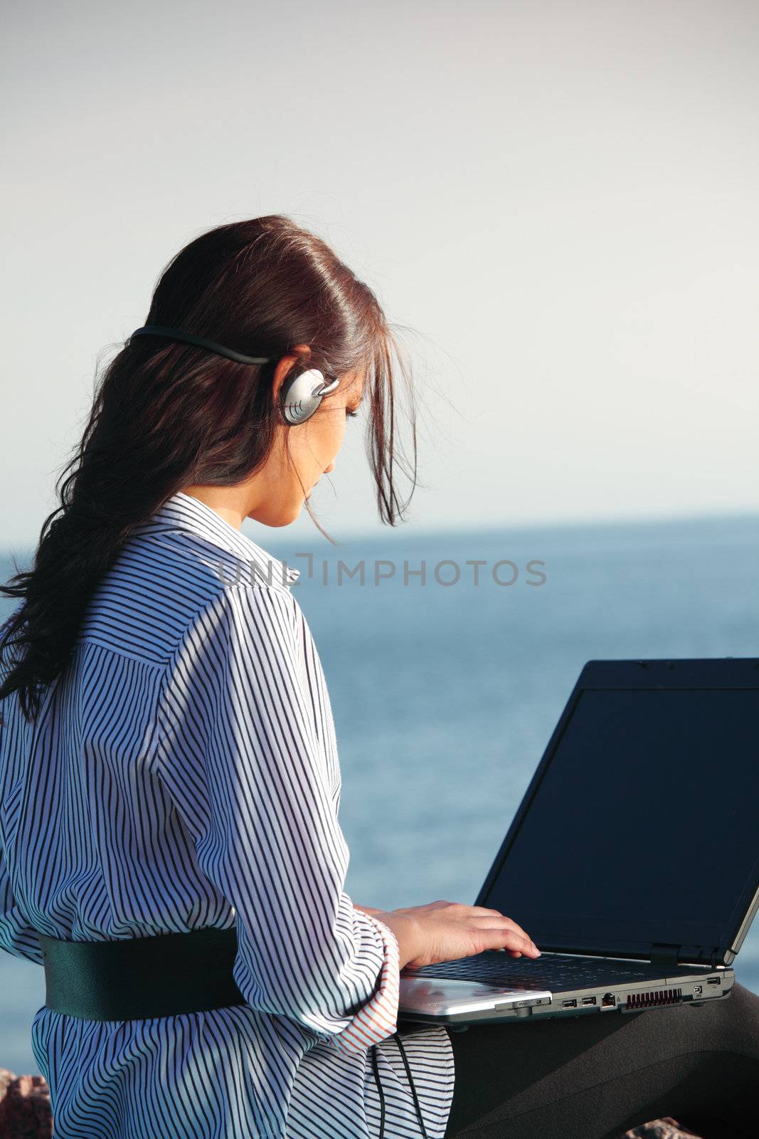 woman with laptop sea background