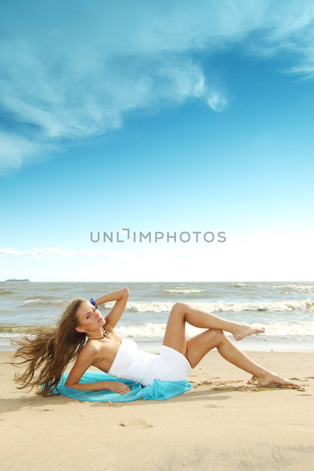 woman laying on sand sea on background