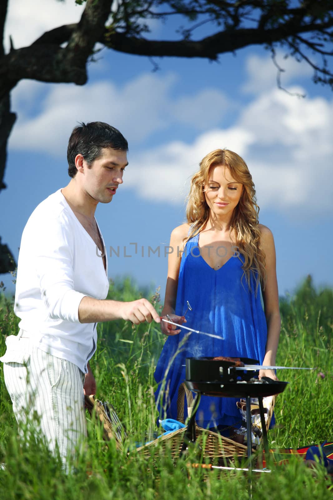 man and woman on picnic in green grass