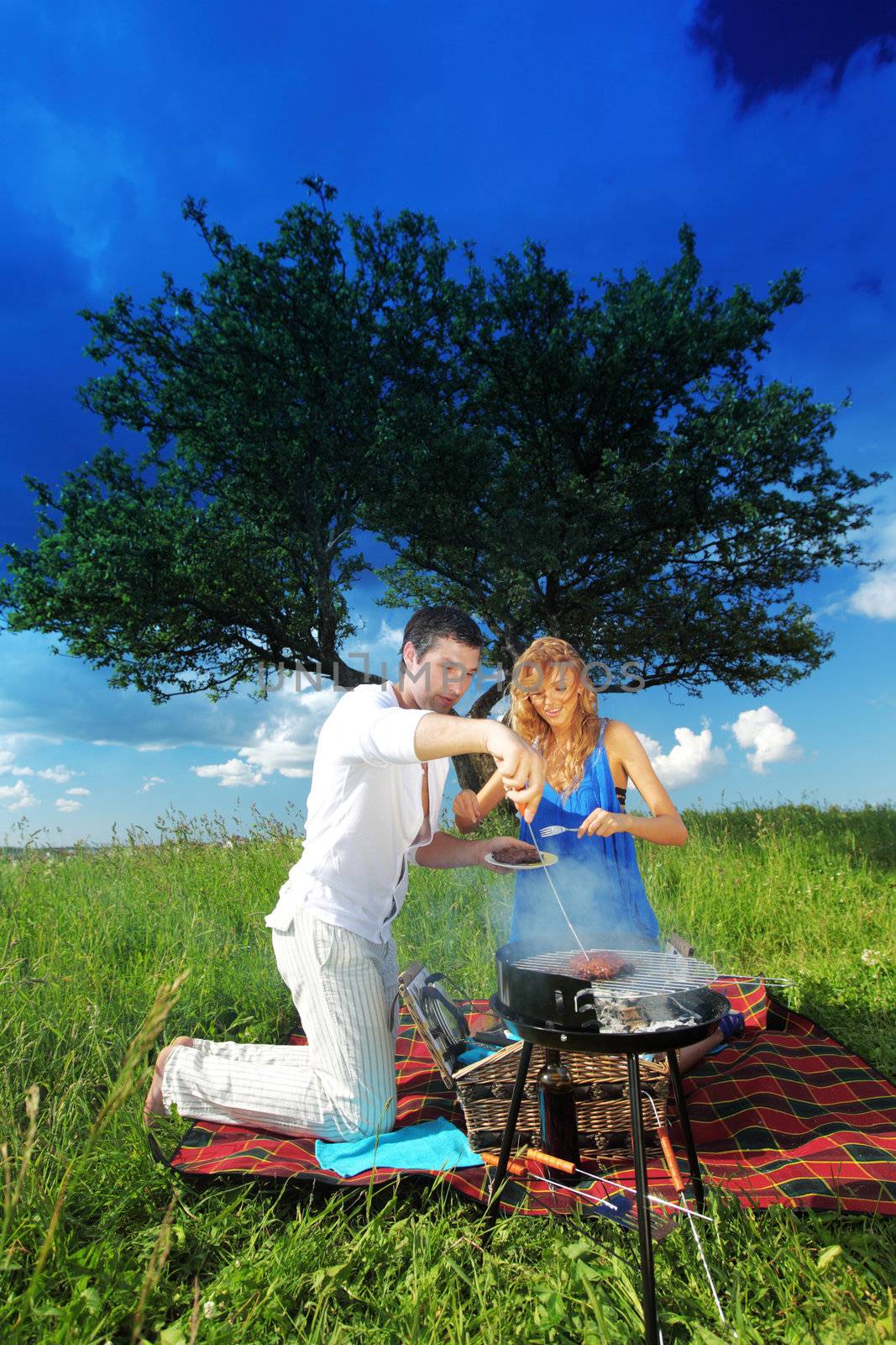 man and woman on picnic in green grass