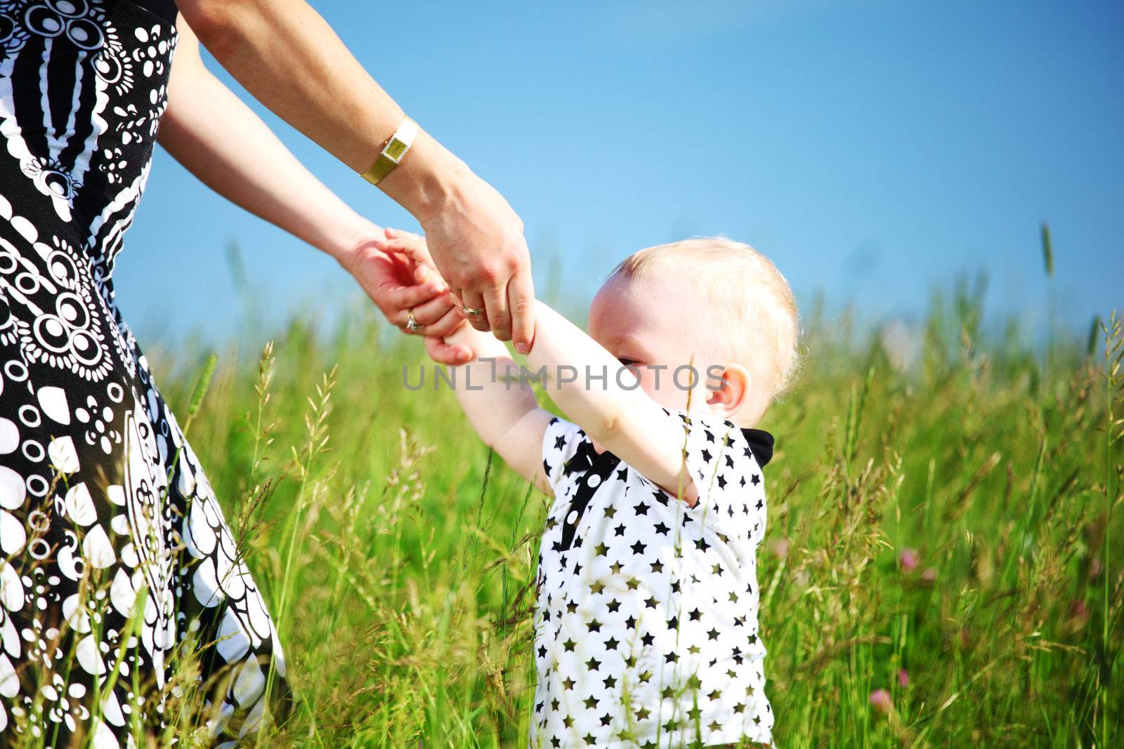 boy and mother hands in grass field