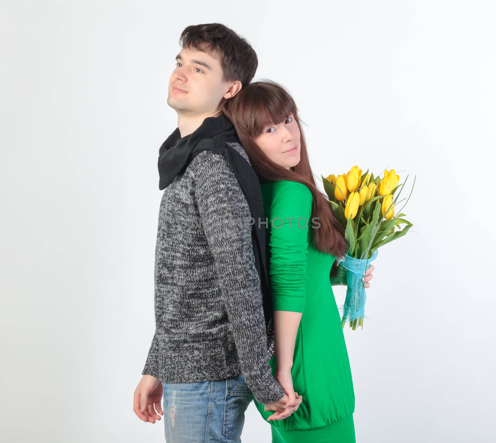 happy young couple with bouquet flowers, on gray background
