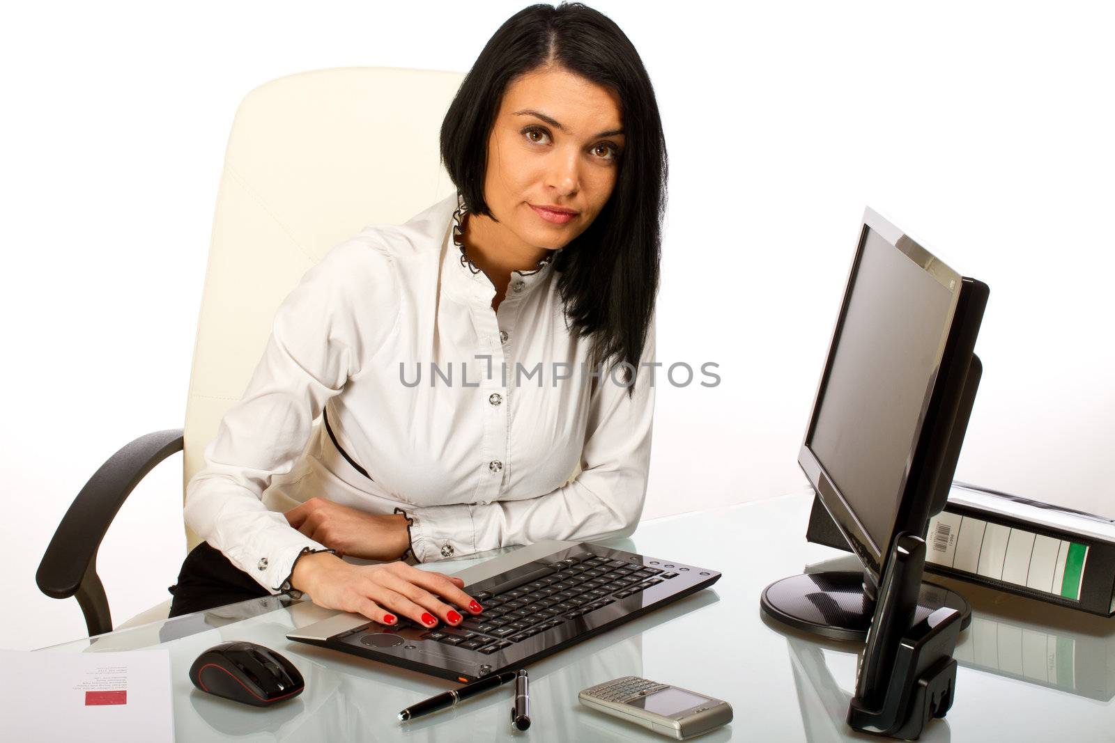 Office worker, secretary at her desk working on a computer