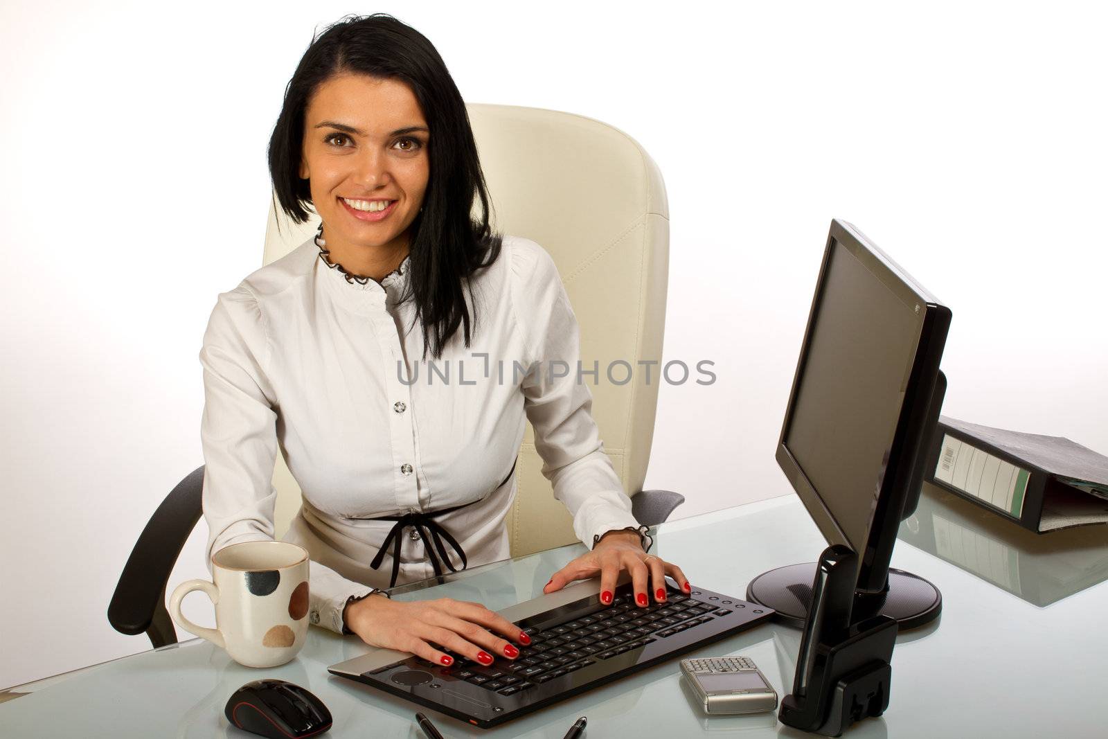 Office worker, secretary at her desk working on a computer