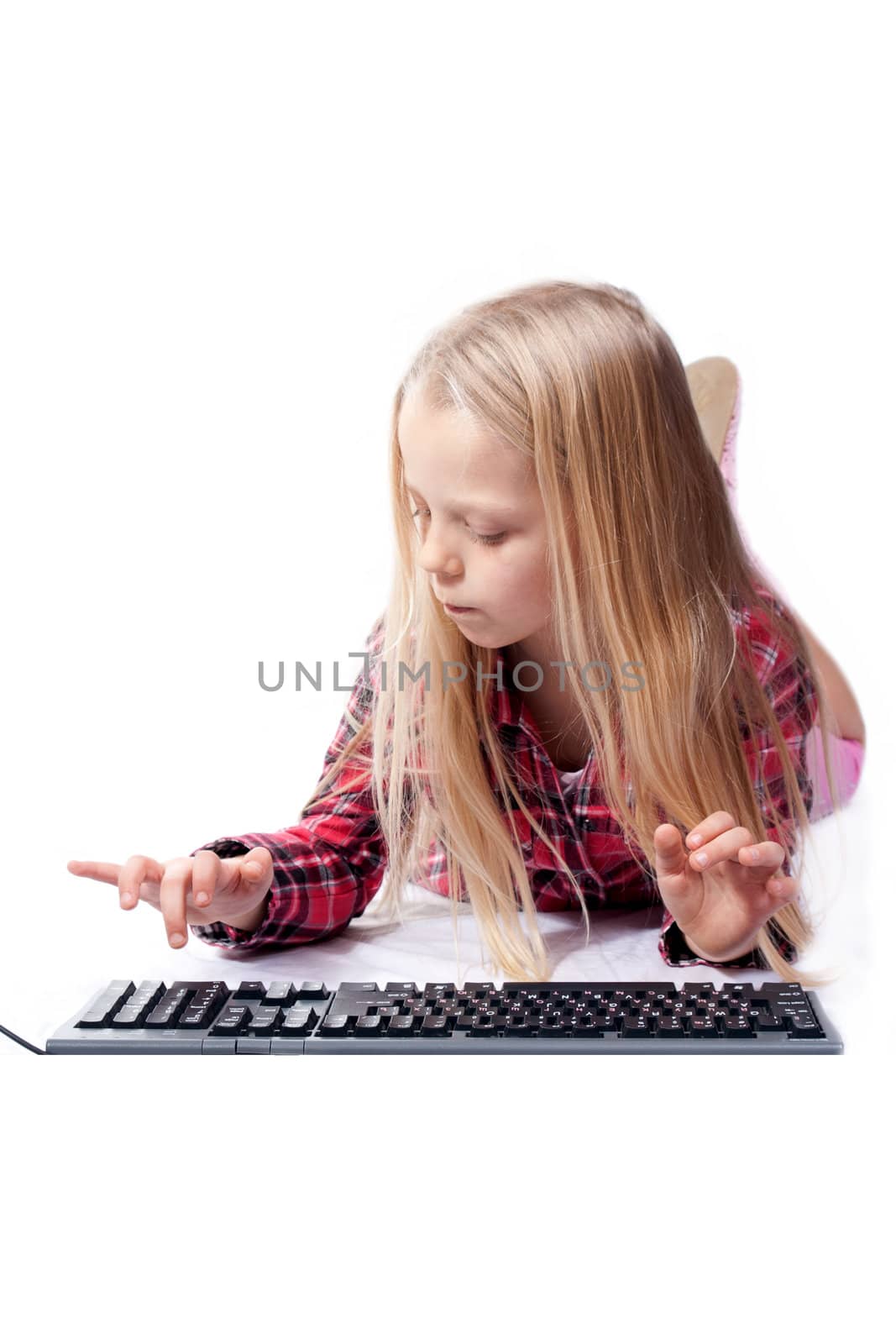 a little girl writes on the PC keyboard