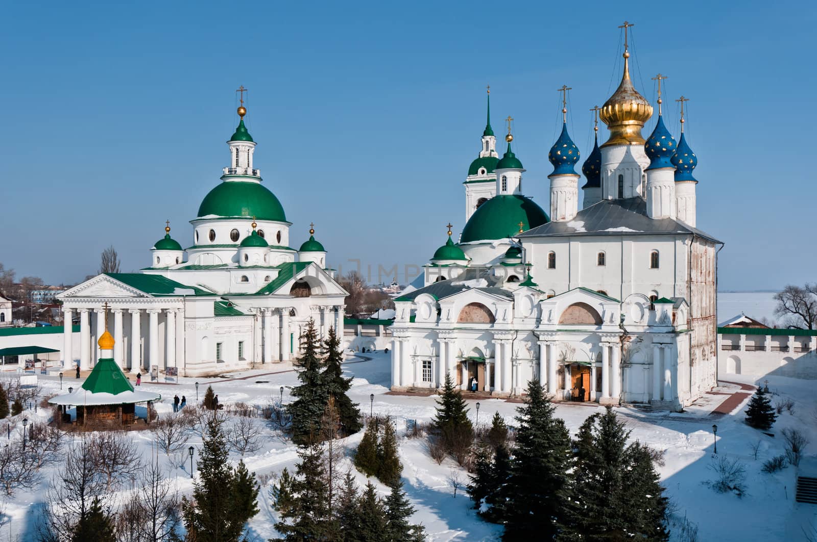 Men monastery in snow, two churches with domes on area