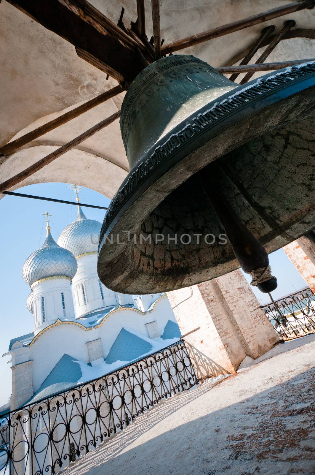 Giant bell with church on background, sky is clear