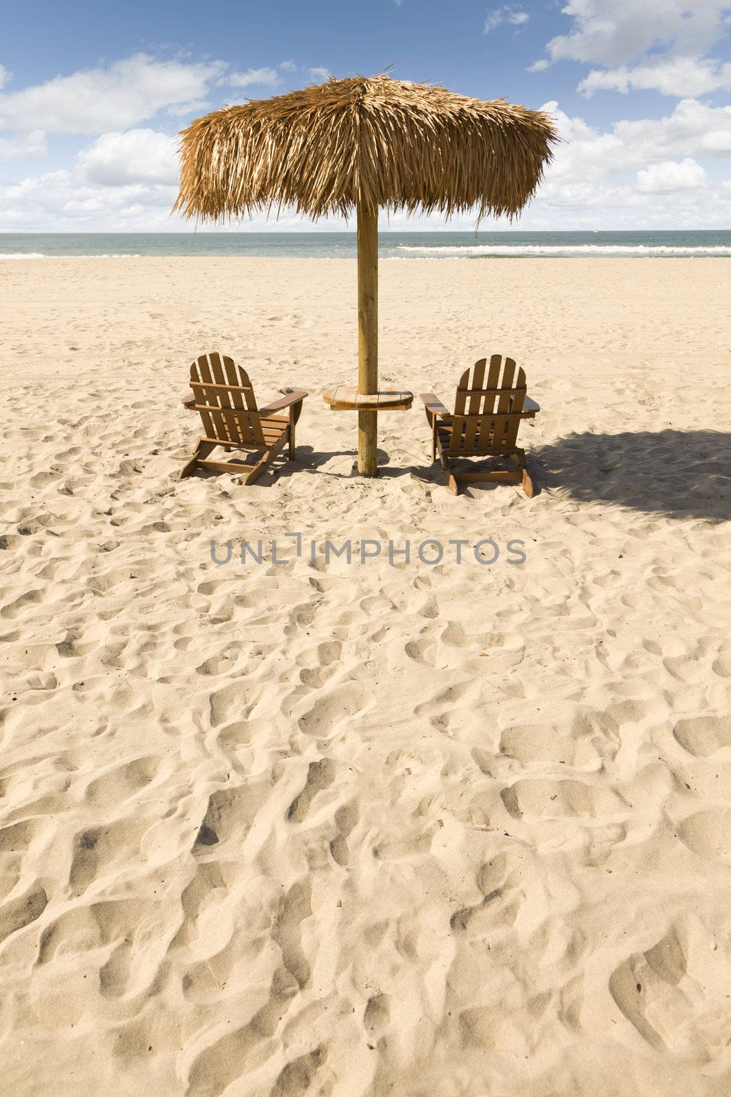 Two Beach Chairs and Umbrella on a Beautiful Ocean Front with Copy Space.