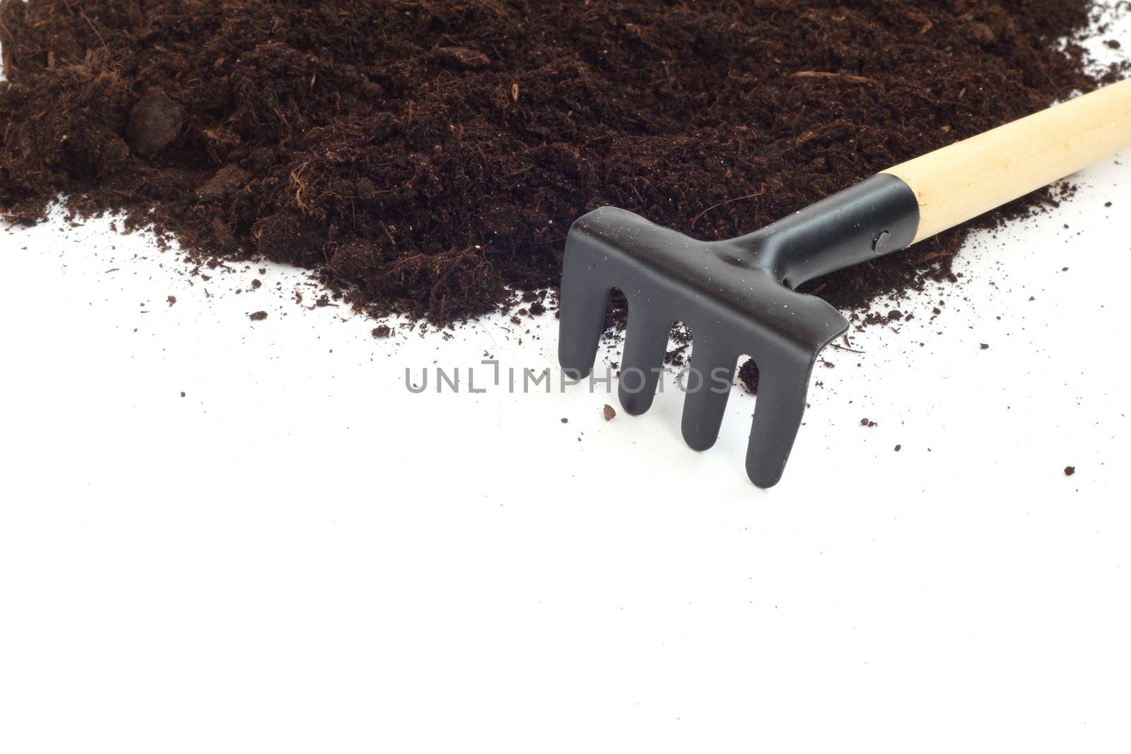 Rake and dirt isolated on white background, gardening concept