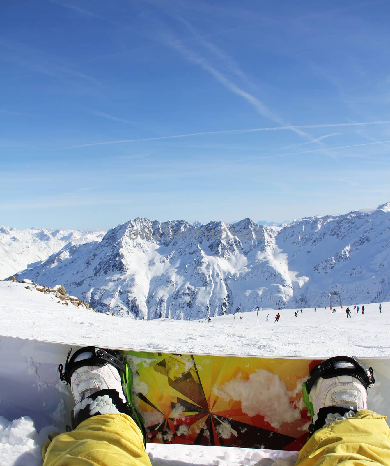 Snowboarder sitting on snow in high mountains