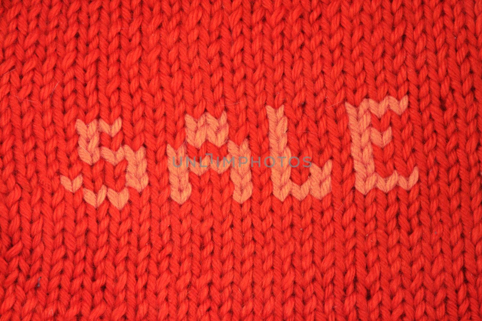 Winter sale concept red knitted background close up