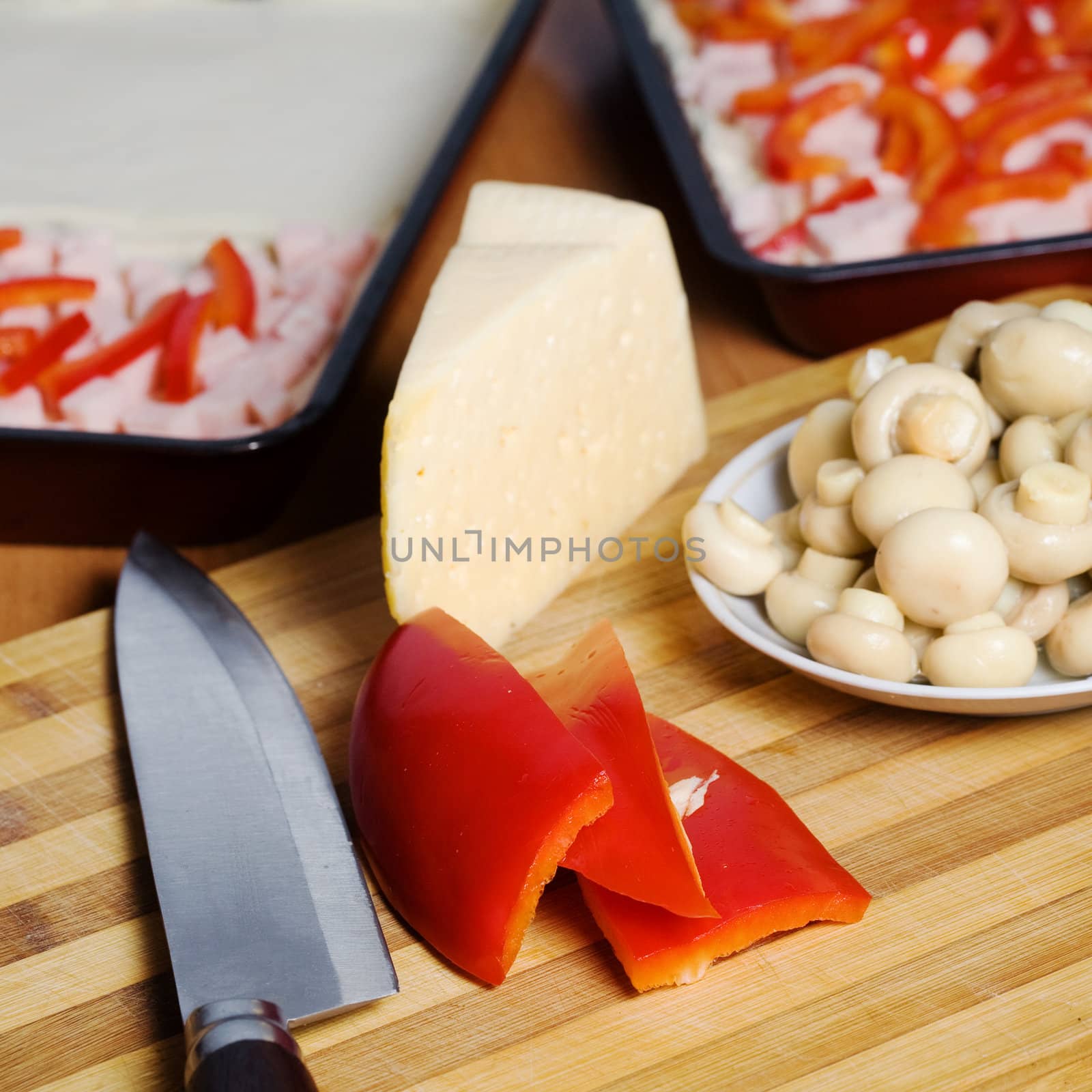 An image of food in the kitchen: mushrooms, paprika, cheese and knife