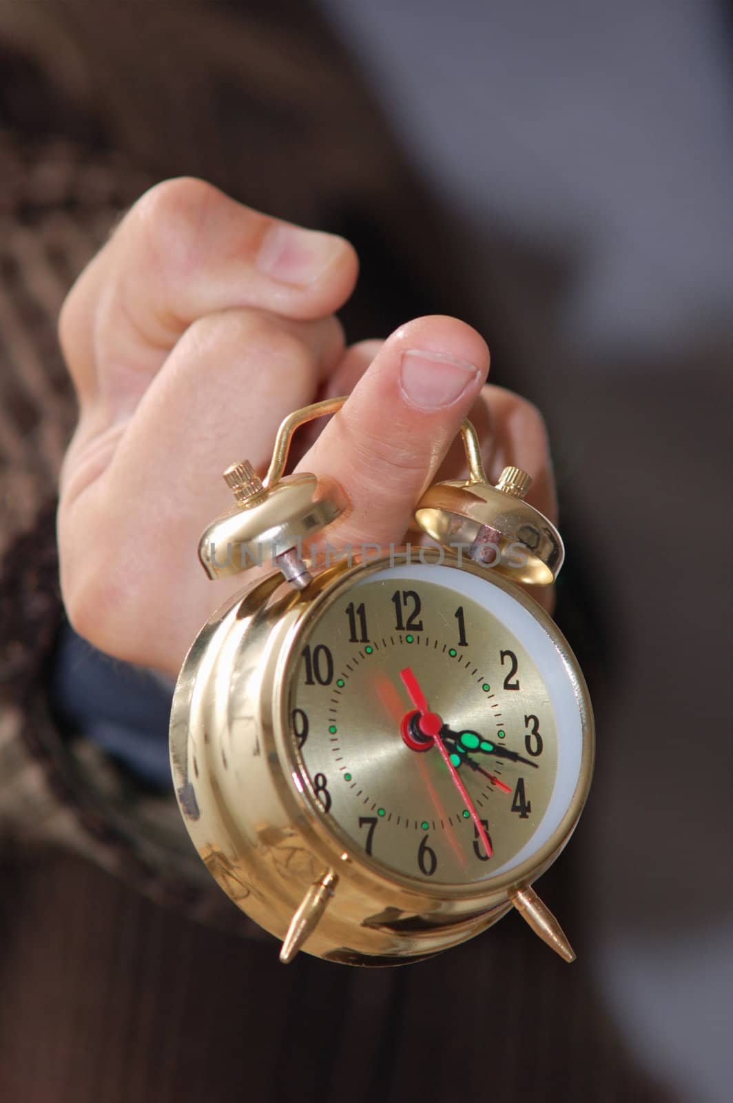 A man keeping an alarm clock on his finger
