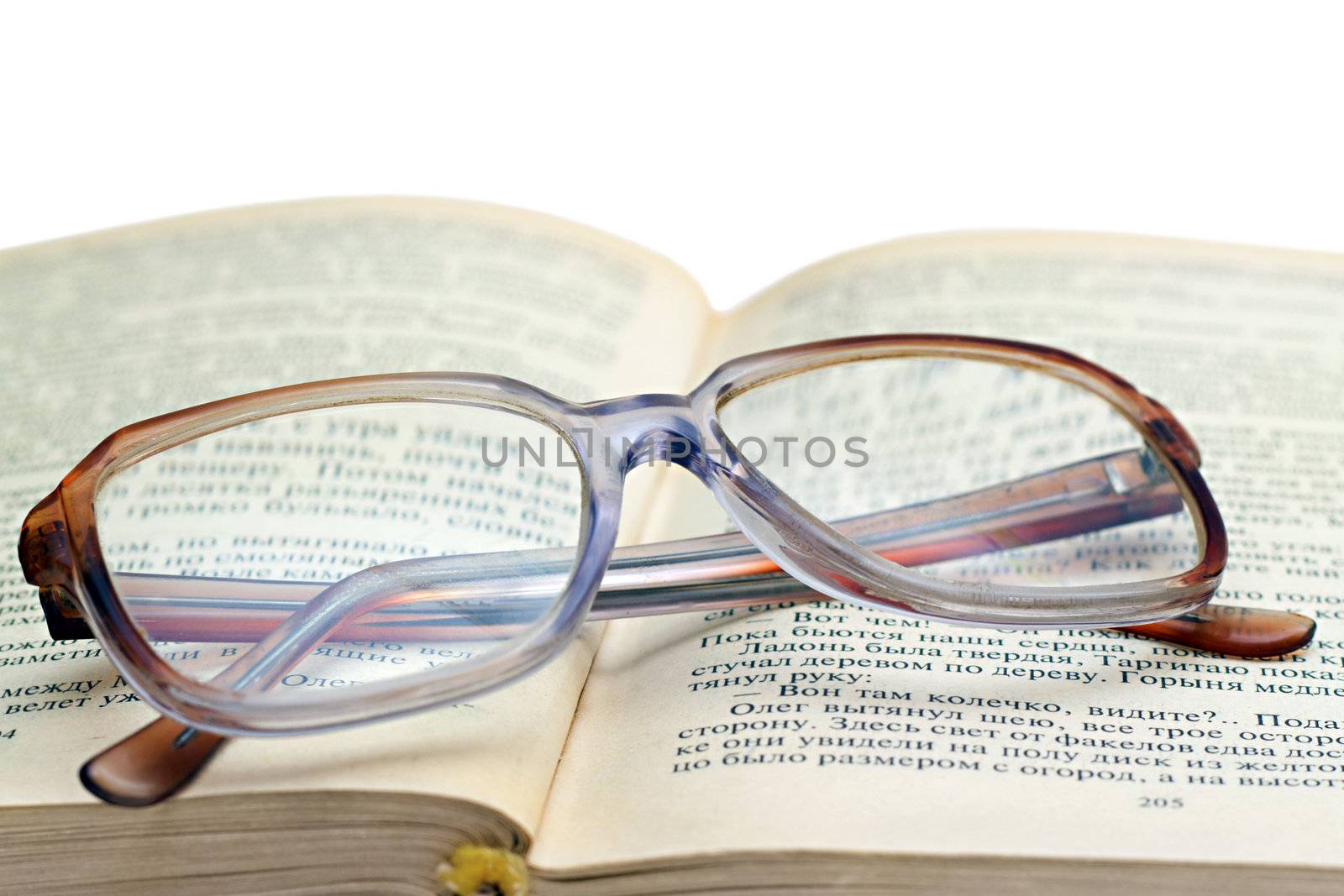 reading glasses lying on the book isolated on white
