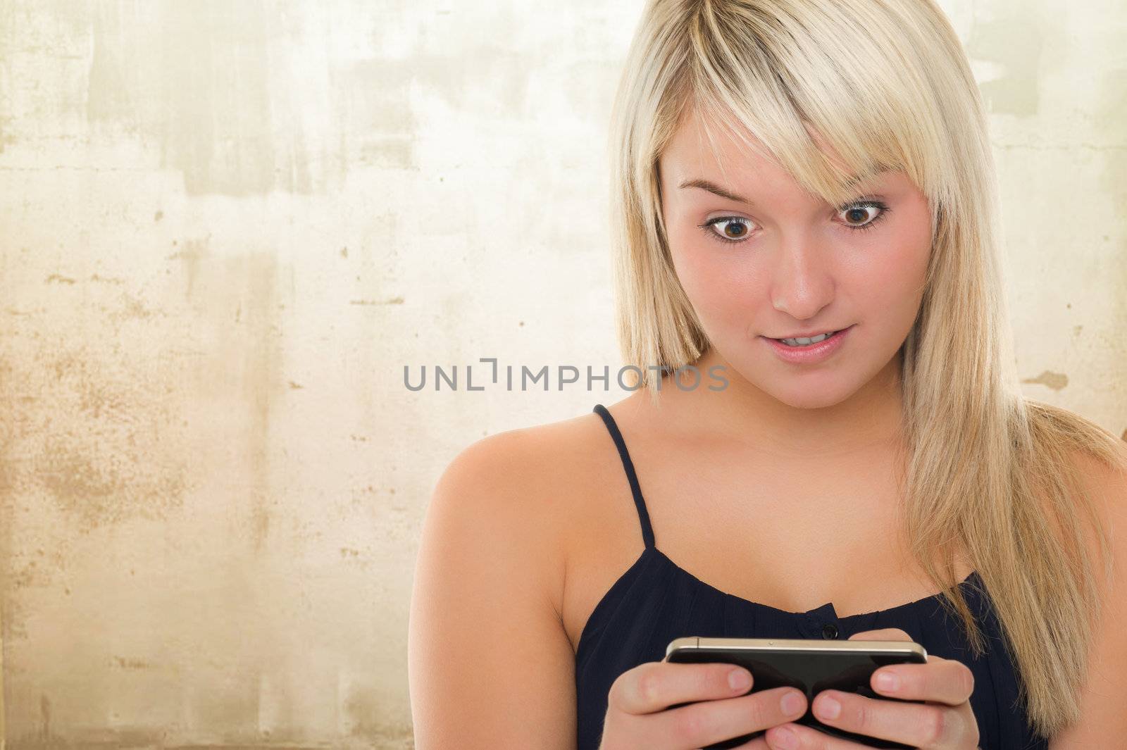 Young surprised beautiful girl with smartphone. Over white background