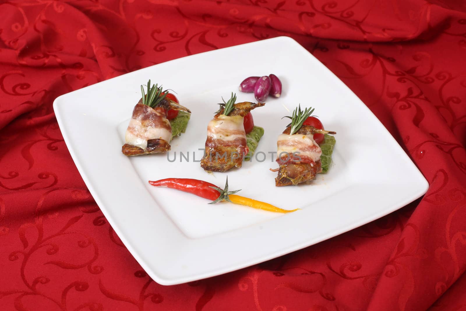 Rolls with bacon and fresh vegetables on a white plate