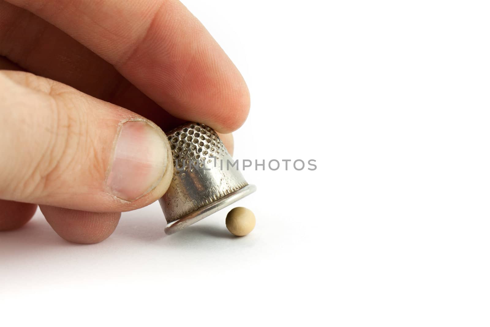 Thimble and pea isolated on white background