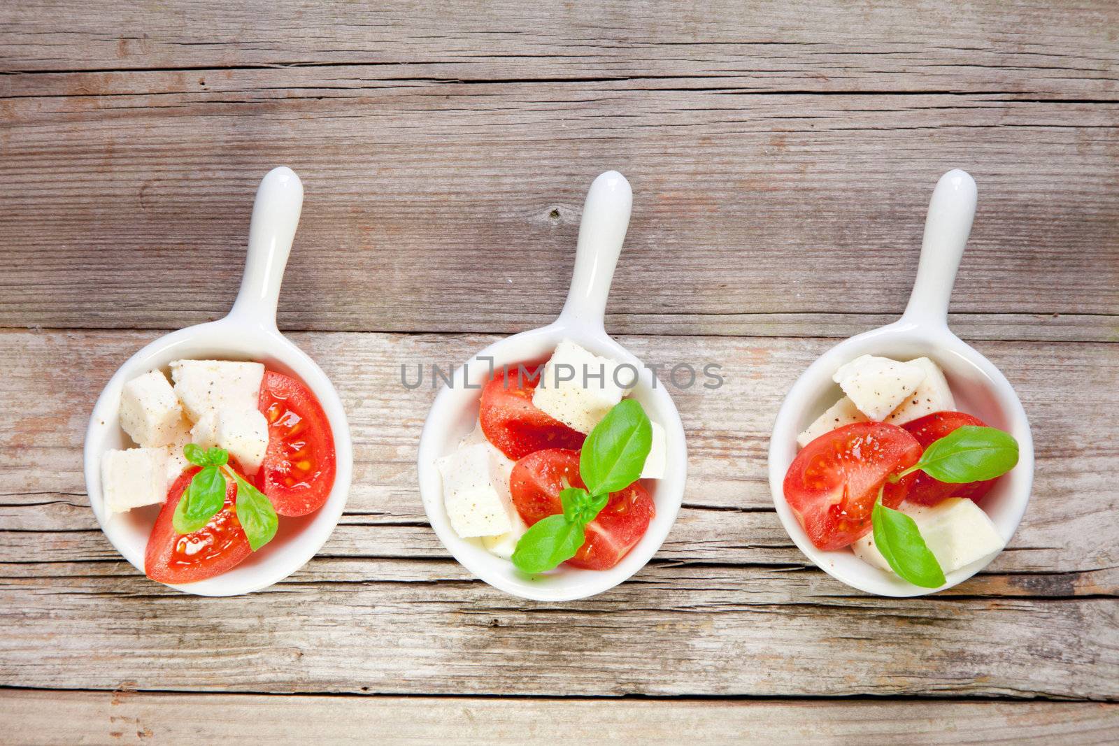 Italian salad with tomatos on rustic wood