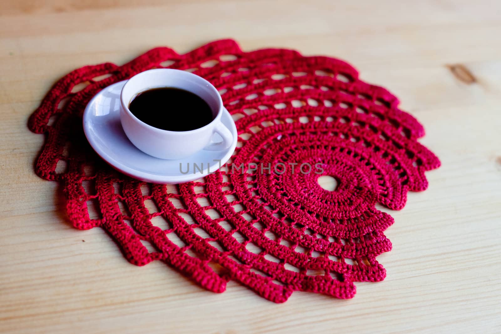 A coffee cup on red napkin on wooden table

