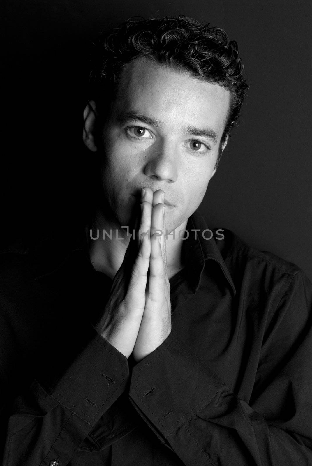 Handsome man portrait with hands on mouth black and white