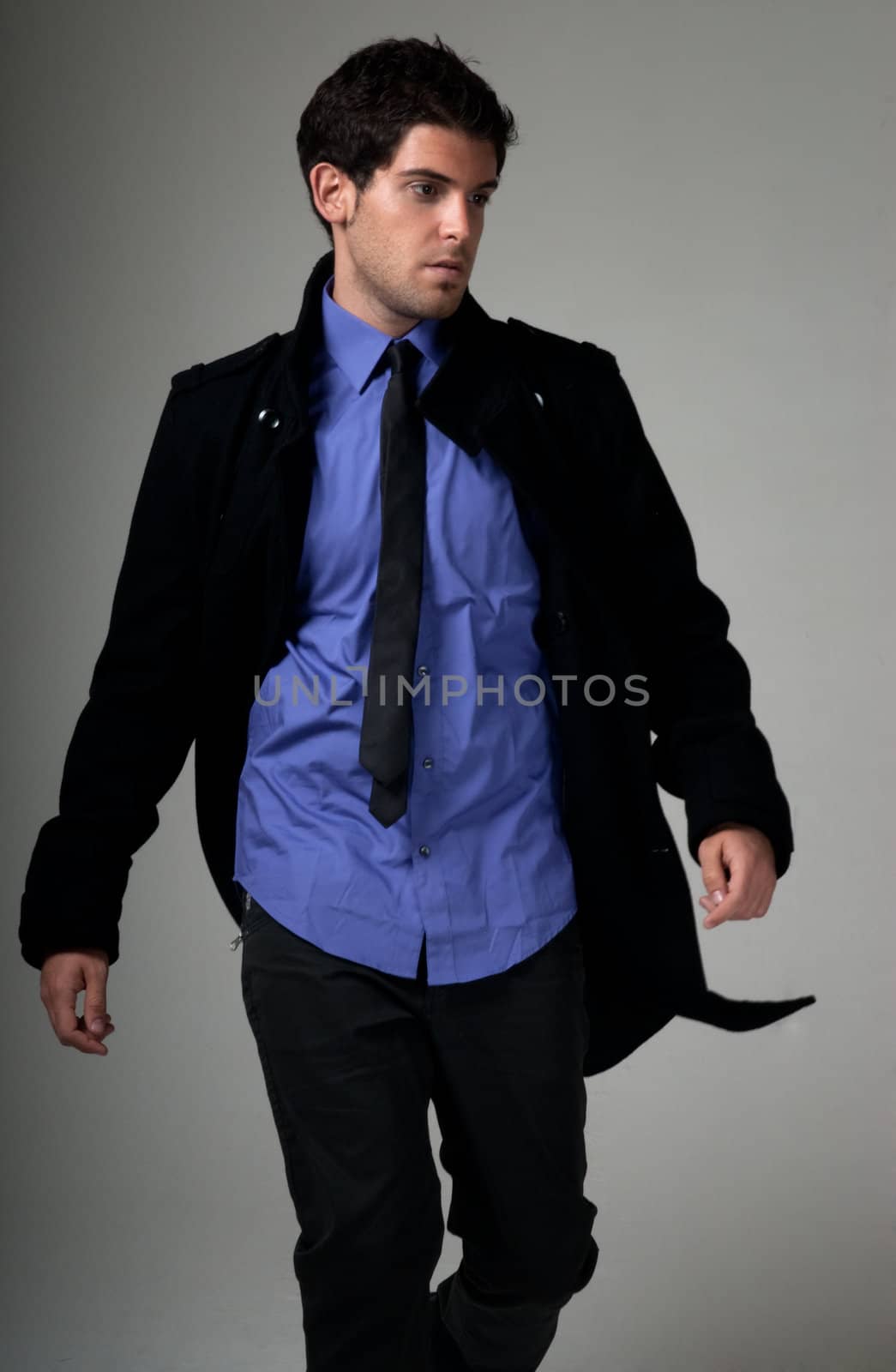 Young man fashion with suit walking over grey background