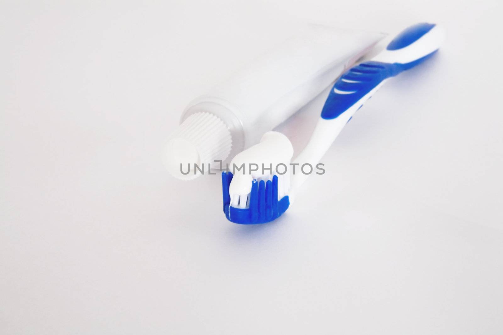 Tube of tooth paste and brush on a white background