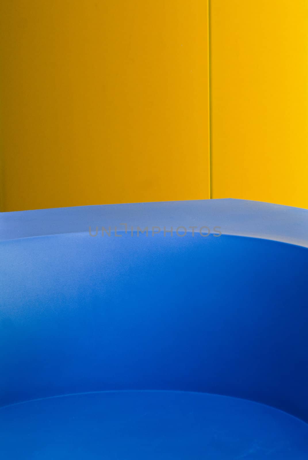 Blue concrete chair in front of yellow pillar