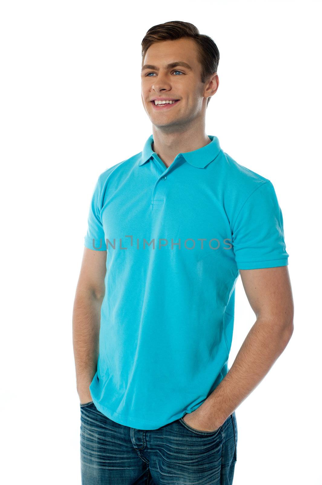 Relaxed handsome young guy looking away while posing with hands in his pocket
