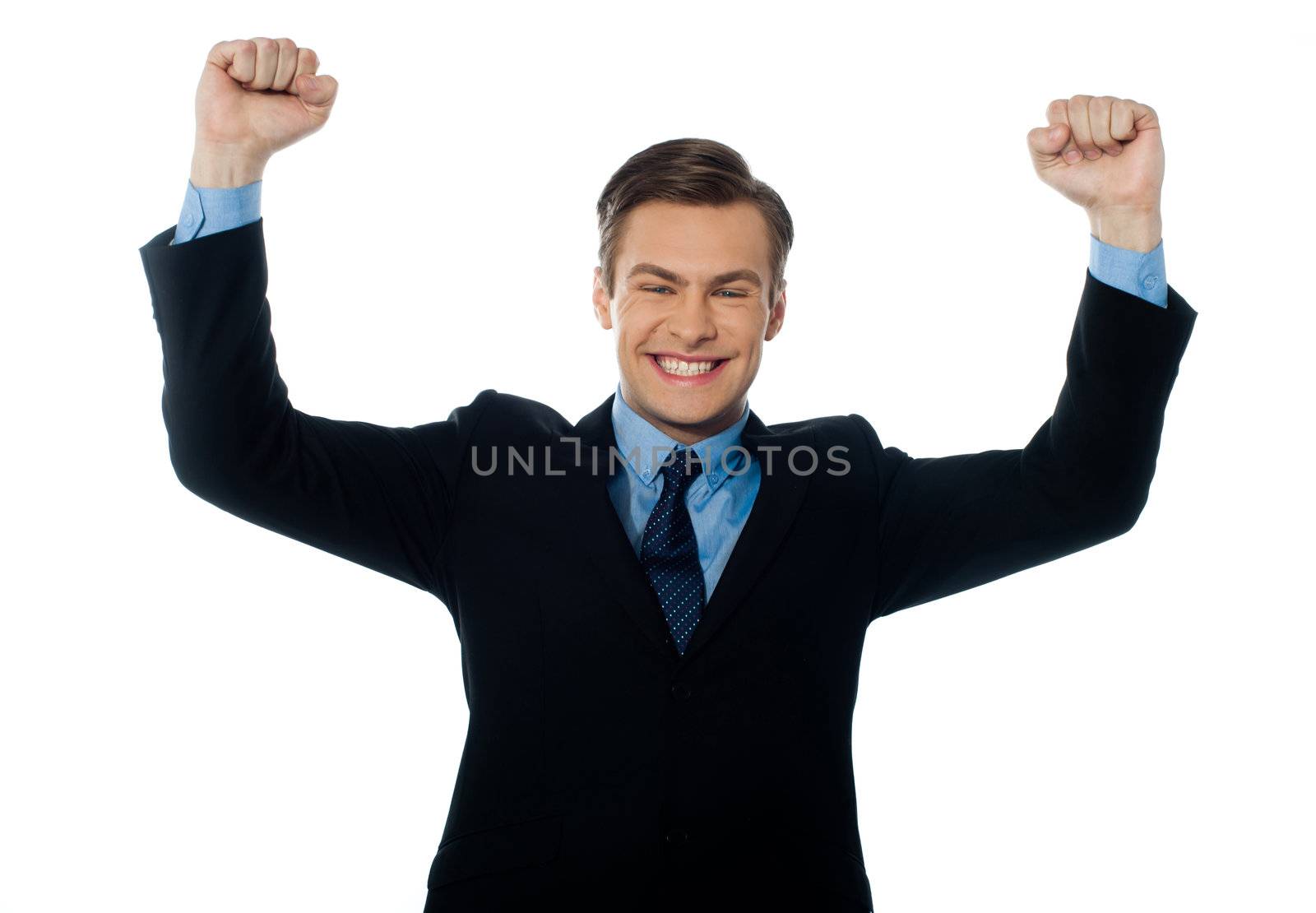 Portrait of confident young businessman celebrating success with arms up