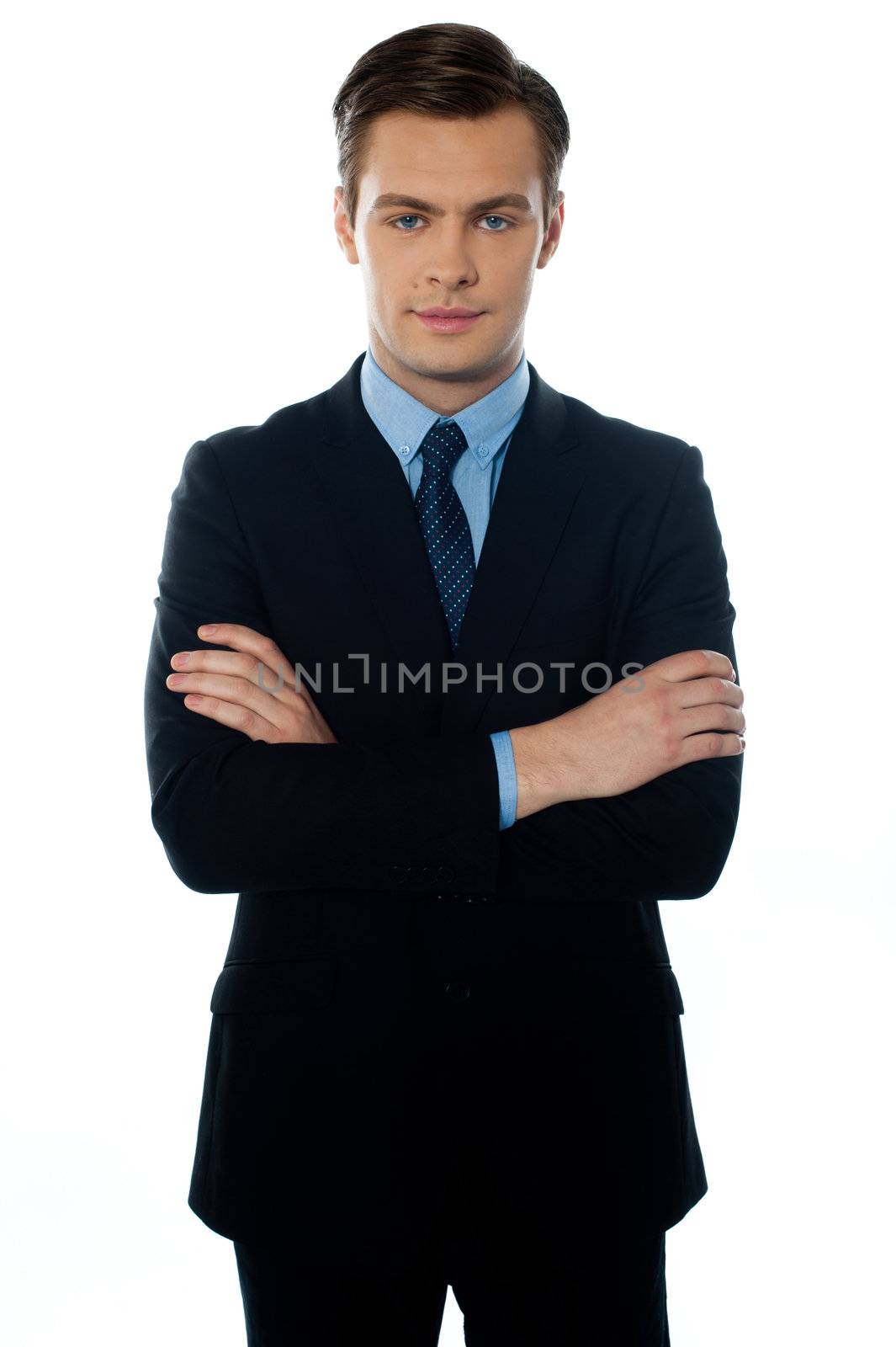Handsome young man in a business suit posing with folded arms
