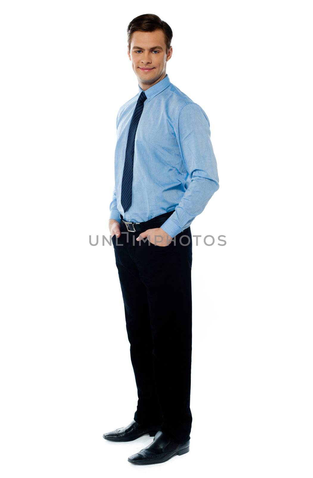 Handsome young business associate standing with hands in his pocket