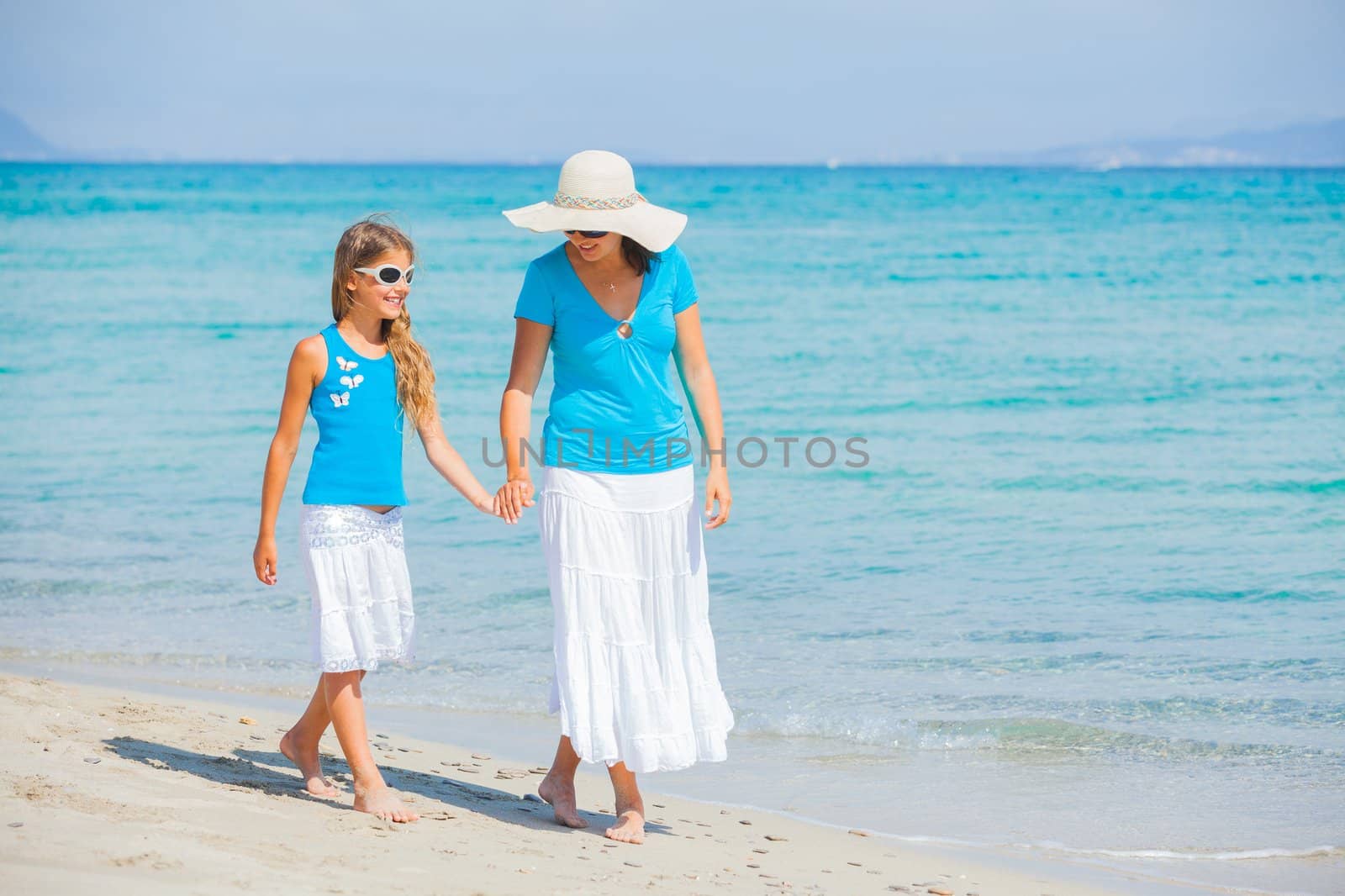Mother and her daughter having fun on tropical beach